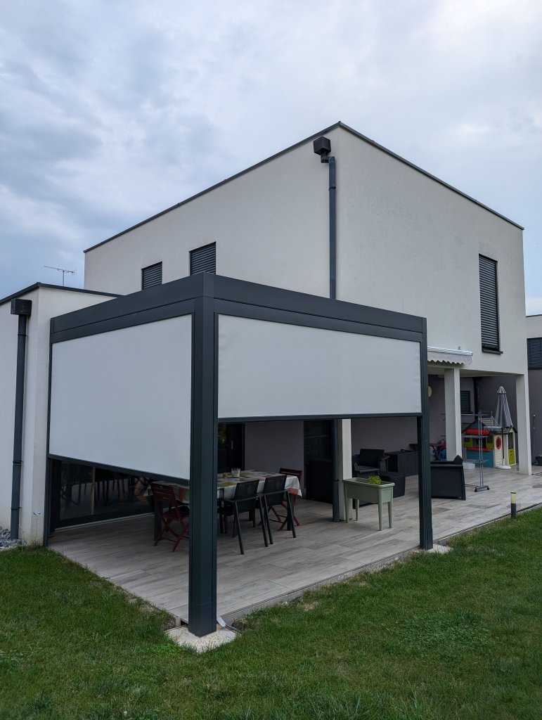 Réalisation pergola bioclimatique - Pergola bioclimatique à lames orientables - Modèle Rayy - Largeur 3,71m x avancé 3,4m - Couleur structure Gris Anthracite RAL 7016 Sablé - Couleur lames Blanc RAL 9010 Satiné - Option deux stores zip motorisés toile Ferrari soltis veozip 51184