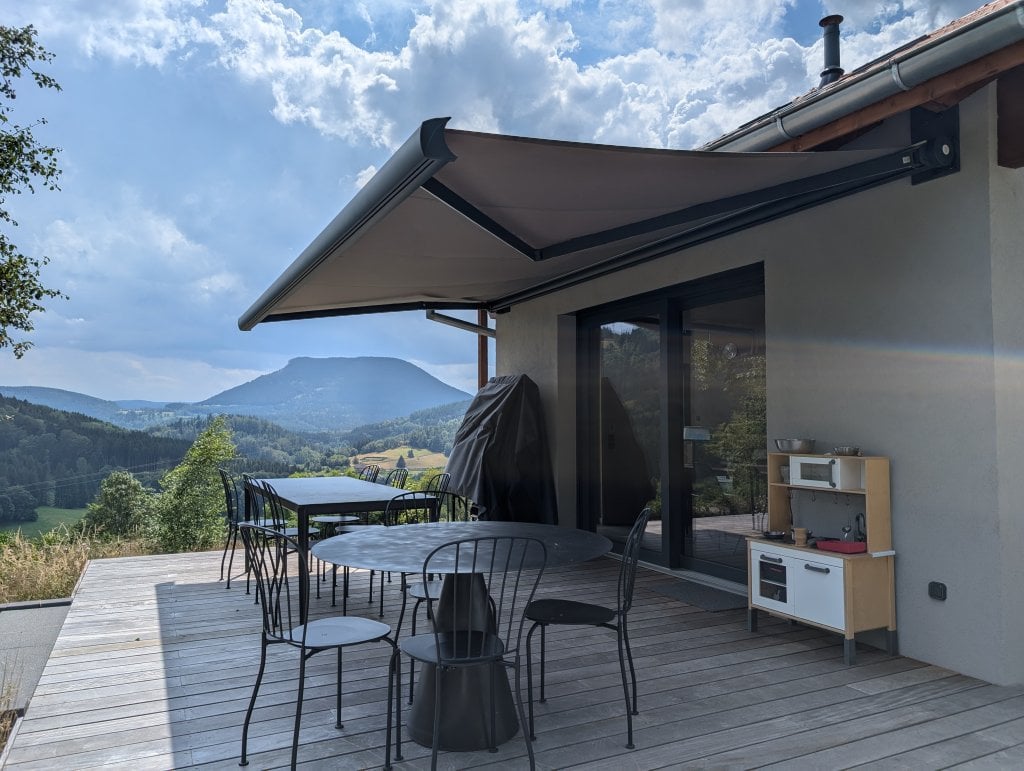 Réalisation store coffre - Store Rayy XL Largeur 530 cm x Avancée 400 cm – Coffre Coloris Gris Anthracite RAL 7016 – Toile Dickson Cèpe Link U785- Pose sur maison ossature bois avec isolation extérieure